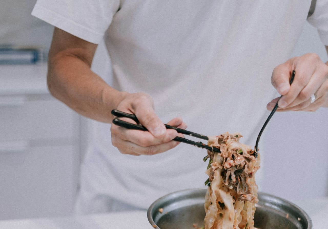 person holding stainless steel spoon and fork